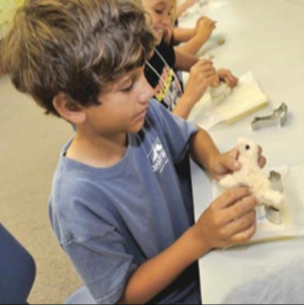 John Cooper Mason, a rising fifth-grader at Smyrna Elementary School, creates a dog from dyed alpaca fleece during The Bridge Downeast summer program at Harkers Island Elementary School (Cheryl Burke photo)